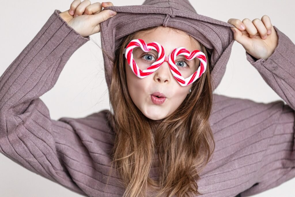 funny-antics-girl-child-in-caramel-glasses-looks-at-the-camera-with-hearts-and-smiles-copy-space-for-text