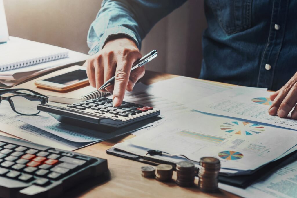 businessman-using-calculator-with-hand-holding-pen-working-in-office